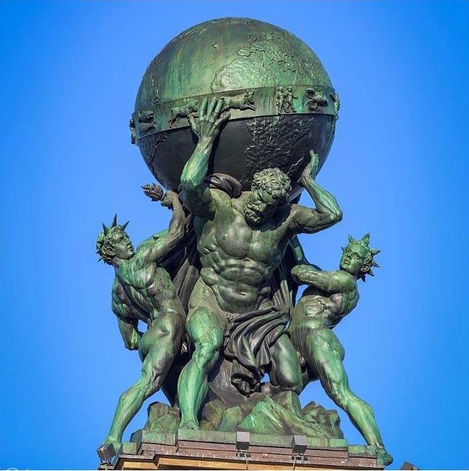 Bronze statue of figures bearing the world aloft — the founder carrying the whole business