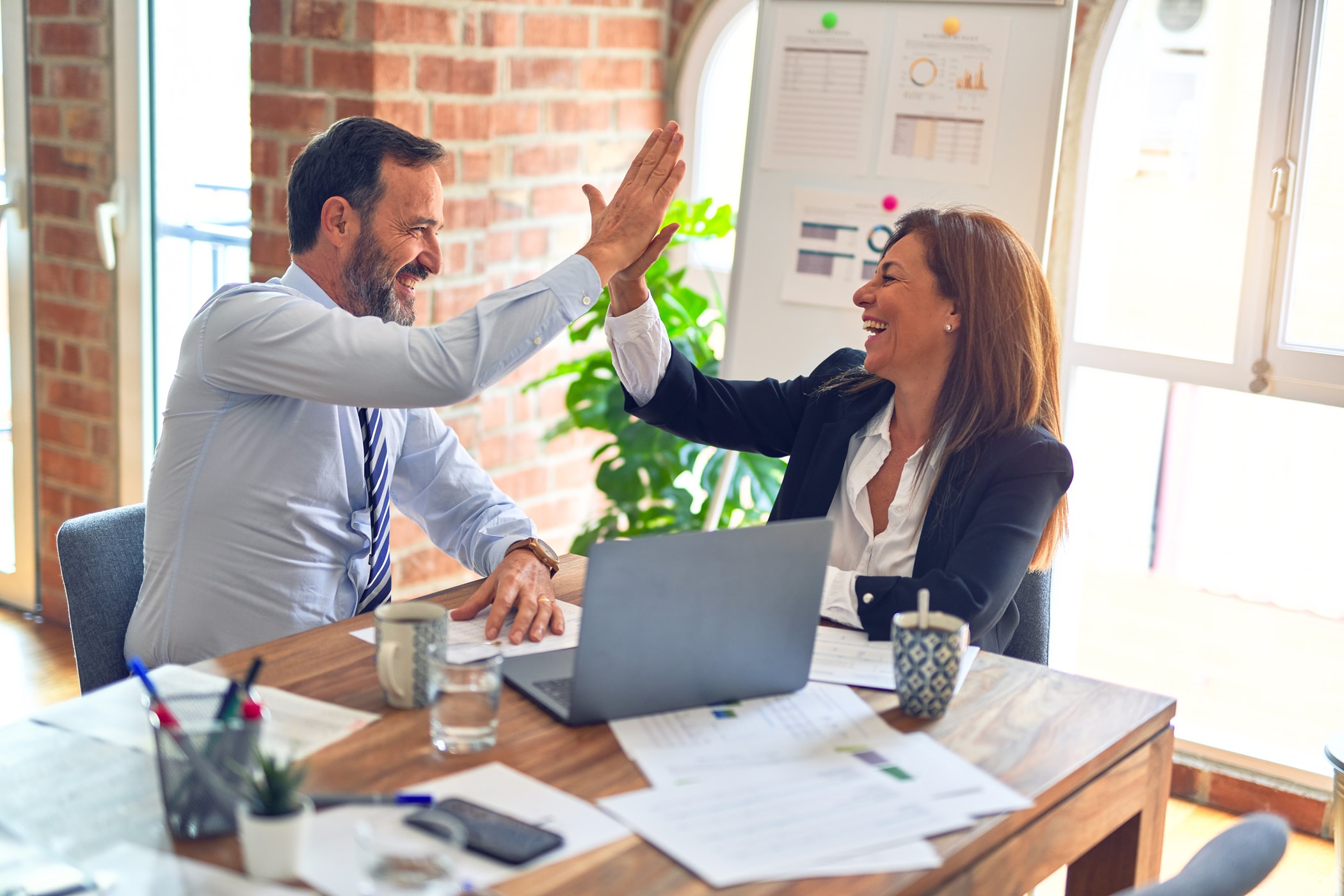 Founder-operators celebrating a win in a systems-run business