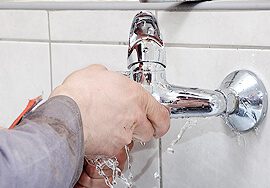 Close-up of hands fixing a plumbing issue