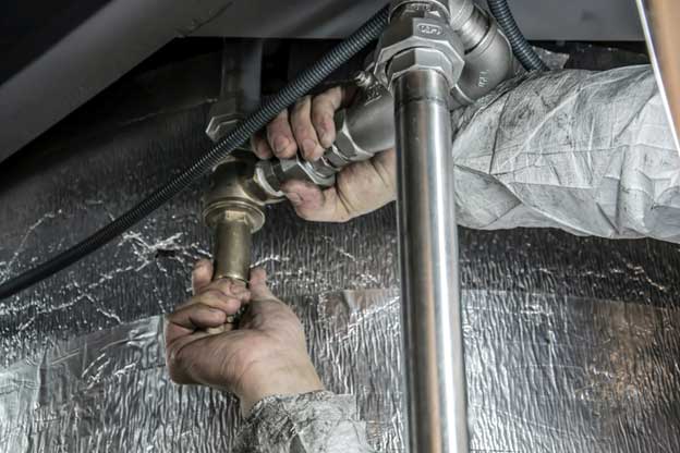 Technician fixing plumbing connections